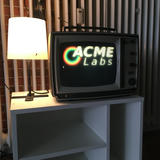 A retro tv with the acme labs logo next to a small lamp.